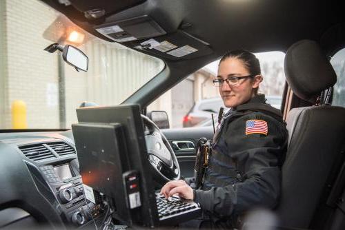 Police officer using a laptop in their vehicle.